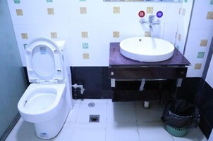 A small bathroom with a toilet, sink, and a trash bin.