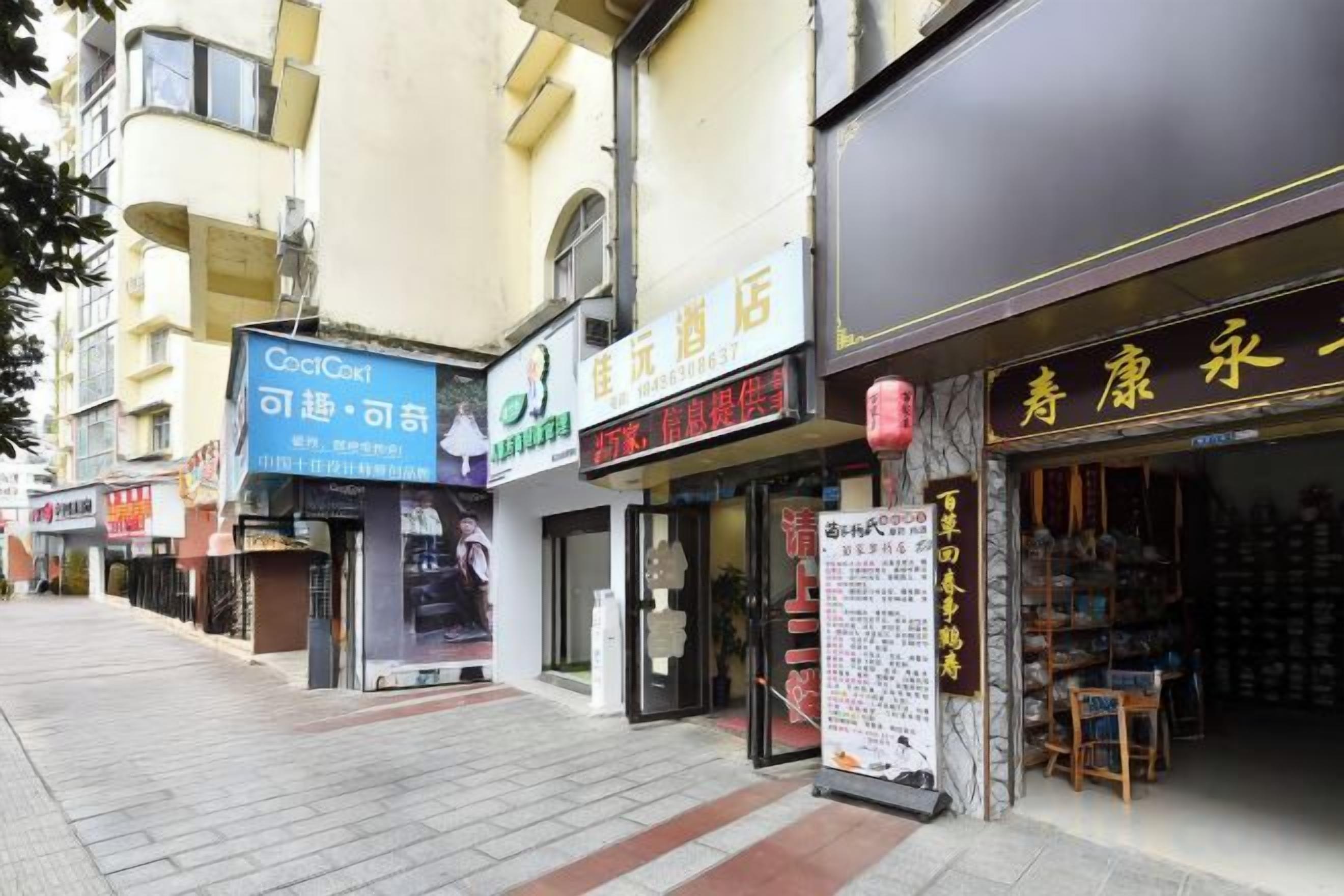 A street view with various storefronts, including a visible sign for a hotel.