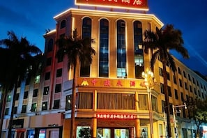 Un hôtel reconnaissable à son grand panneau rouge, à ses nombreux étages et à son style architectural classique.