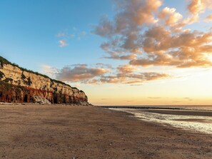 A coastal landscape with a sandy beach, cliffs, and a clear sky. - 2 bedroom accommodation in Hunstanton (Hunstanton)