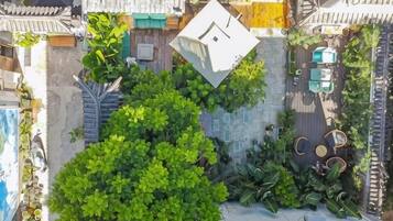 Vista aérea de un jardín en la azotea con plantas diversas y zonas de estar.