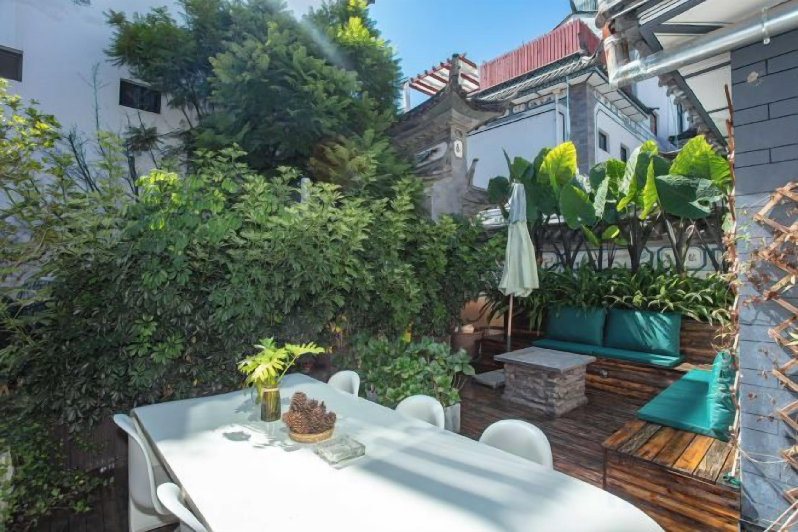 Un patio con mesa, sillas y una terraza de madera.