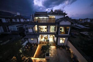 A traditional multi-story building with a courtyard, large windows, and a well-lit entrance. - Erduobian Inn (Dali City)