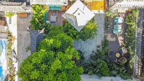 An aerial view of a rooftop garden with a seating area, surrounded by buildings. - Erduobian Inn (Dali City)
