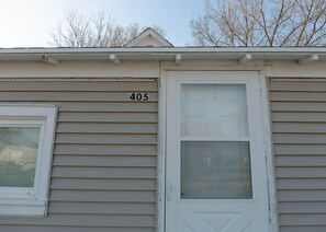 Un bâtiment avec une porte blanche et une fenêtre, portant le numéro 405.