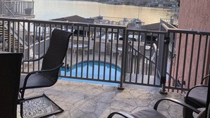 Ein Balkon mit Blick auf einen See, ein Schwimmbad und einen Steg.