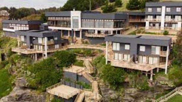 Un moderno complejo residencial con varias casas de dos pisos, con balcones y ventanas amplias.