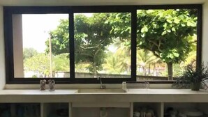 Une cuisine avec une fenêtre donnant sur un jardin.