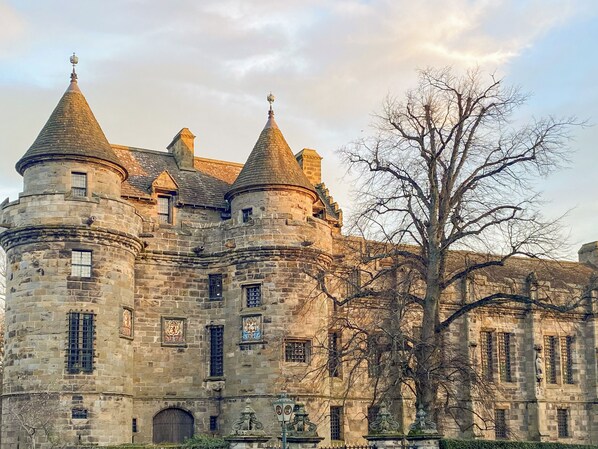 A historic stone castle with multiple towers and arched windows.