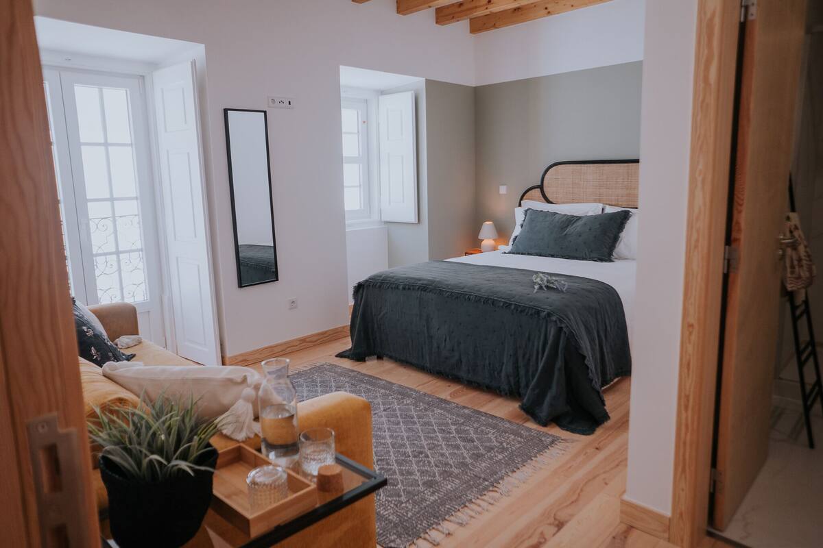 A bedroom with a bed, bedside table, and a window.
