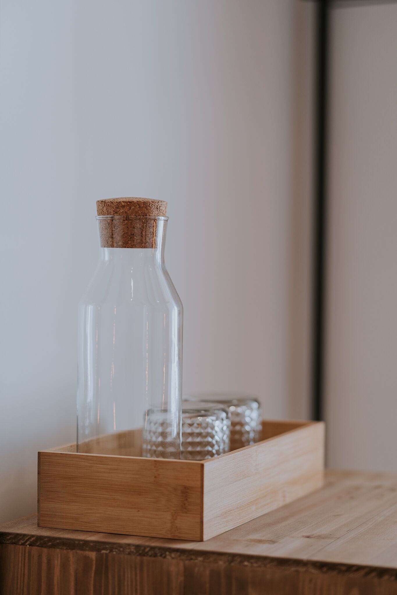 Een glazen fles met kurkprop op een houten ondergrond.