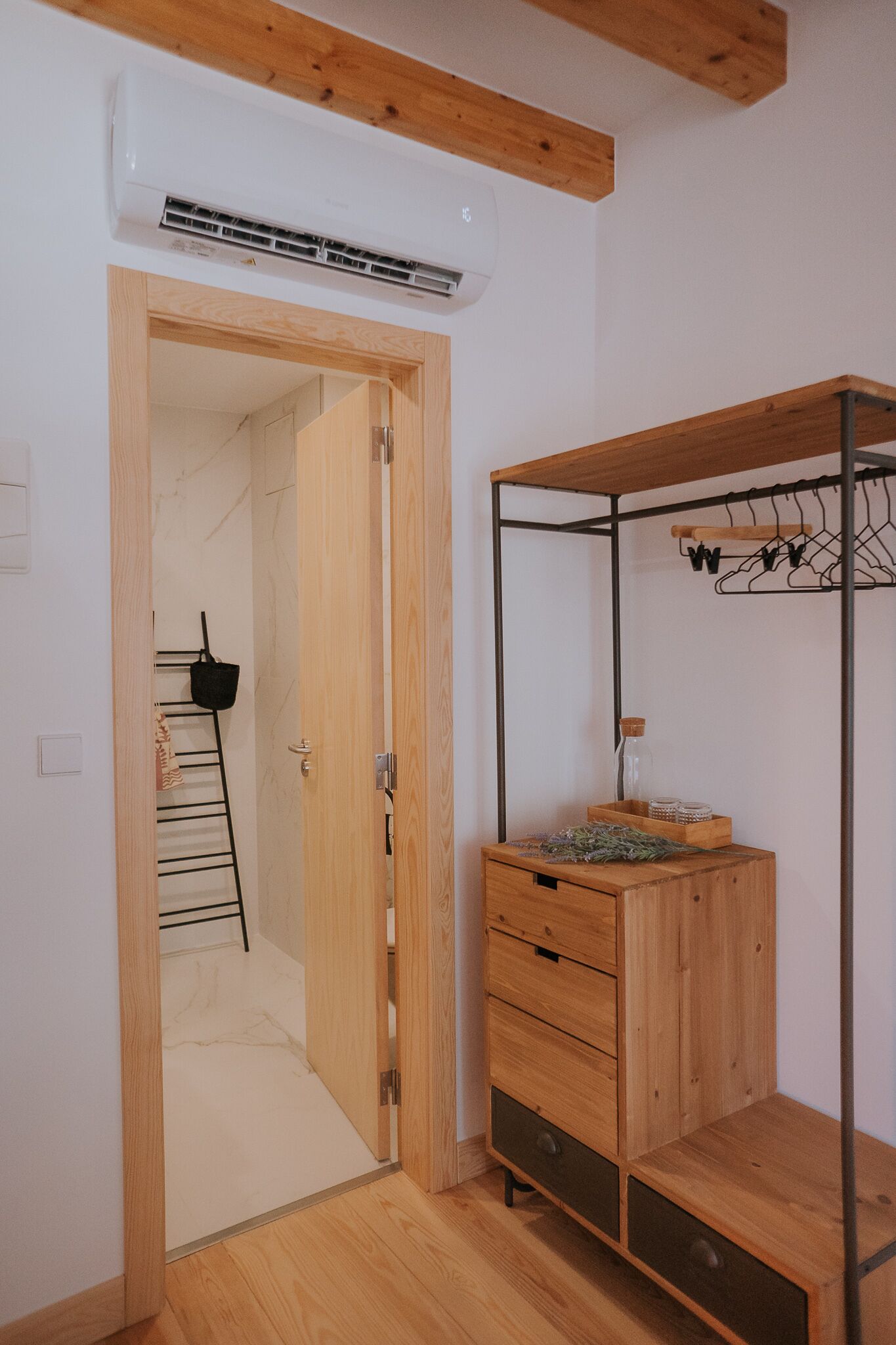Un dormitorio con un armario de madera, una estructura de cama metálica y techo de madera.