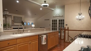 A modern kitchen with wooden cabinets, stainless steel appliances, and a large island. - The Wild Rose ~ A Custom Glam Cottage with Theater! In Historic Old St Charles (Saint Charles)