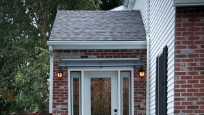 A brick house with a front door, a small porch, and a pathway leading to the entrance. - The Wild Rose ~ A Custom Glam Cottage with Theater! In Historic Old St Charles (Saint Charles)