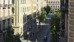 A street view with buildings, trees, and a mountain in the background. - Hotel Roma 62 (Palermo)