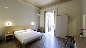 A bedroom with a bed, bedside table, wardrobe, and a view to the outside. - Hotel Roma 62 (Palermo)