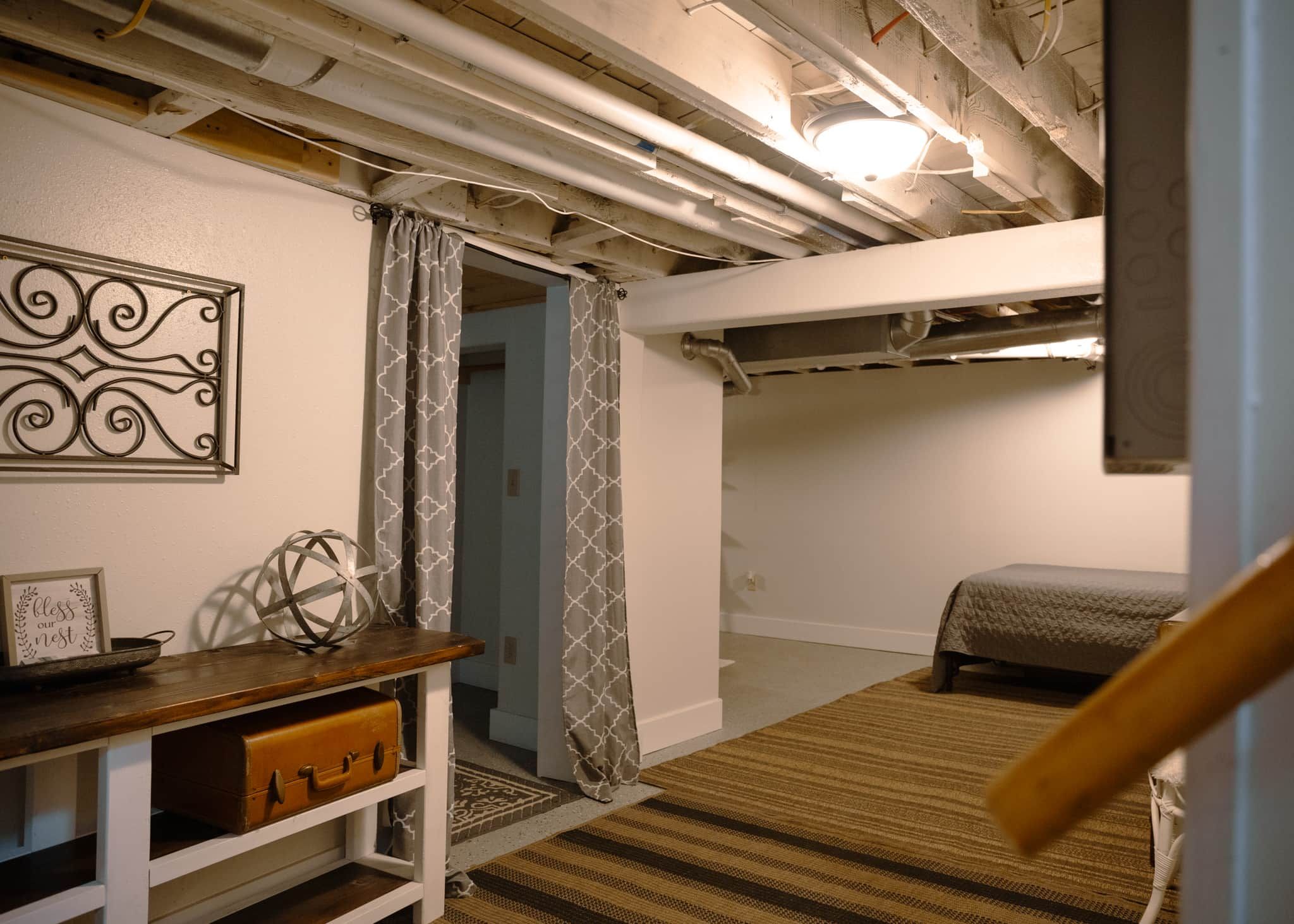 A bedroom with a bunk bed, a desk with a globe, and a decorative wall piece.