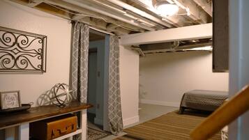 A bedroom with a bunk bed, a desk with a globe, and a decorative wall piece.