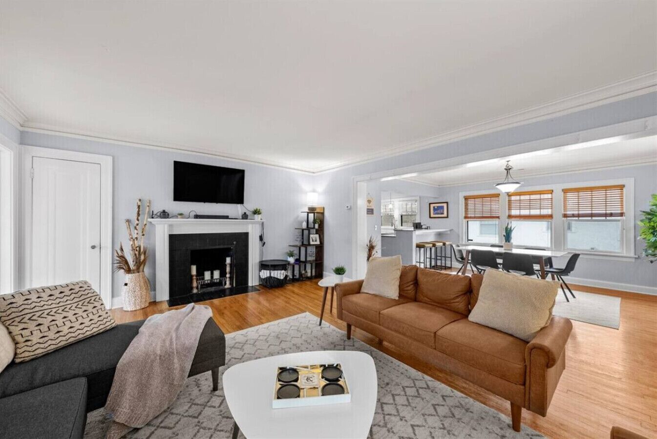 Un salon moderne avec une cheminée, un canapé, une table basse et un coin repas à l’arrière-plan.