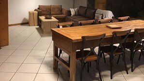 Una sala de estar acogedora con una mesa de comedor de madera y sillas, un sofá y una chimenea.