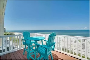 Enjoy the serene ocean views from this deck, featuring a pair of Adirondack chairs and a small table.