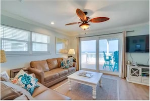 Relax in this inviting living room with a sofa, coffee table, and TV, plus a balcony with a view.