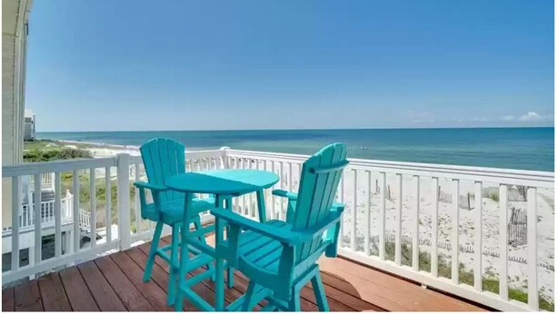 A wooden deck with turquoise chairs and a table overlooking the beach. - Oceanfront family-sized beach house (Cape San Blas)
