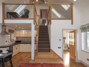 A modern kitchen with white cabinets, a microwave, and a dining area with a table set for two.