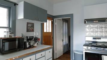 A compact kitchen with a microwave, coffee maker, and stove.