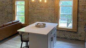 A kitchen with a central island, pendant lighting, and large windows. - Moments to Fiserv Forum and Downtown Milwaukee! (Milwaukee)