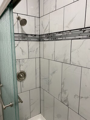 Een douche, handdoeken, zeep, toiletpapier
