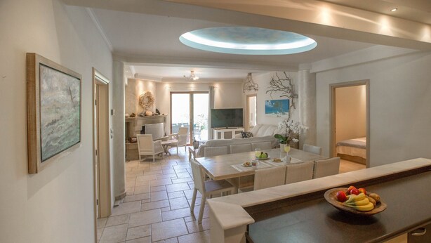 A modern kitchen with a dining area, a small living space, and a view of the outdoors.