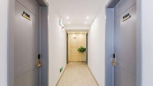 Corredor com duas portas identificadas como F206 e F202, que dão para um espaço com porta de madeira e planta em vaso.
