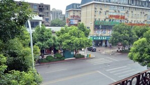 A street view with buildings, trees, and a crosswalk. - Huashuwanbinguan (Changsha)