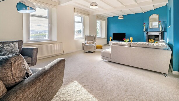 A spacious living room with a large window, a fireplace, and a television. - Shawdon Hill Cottage (Glanton, Alnwick)