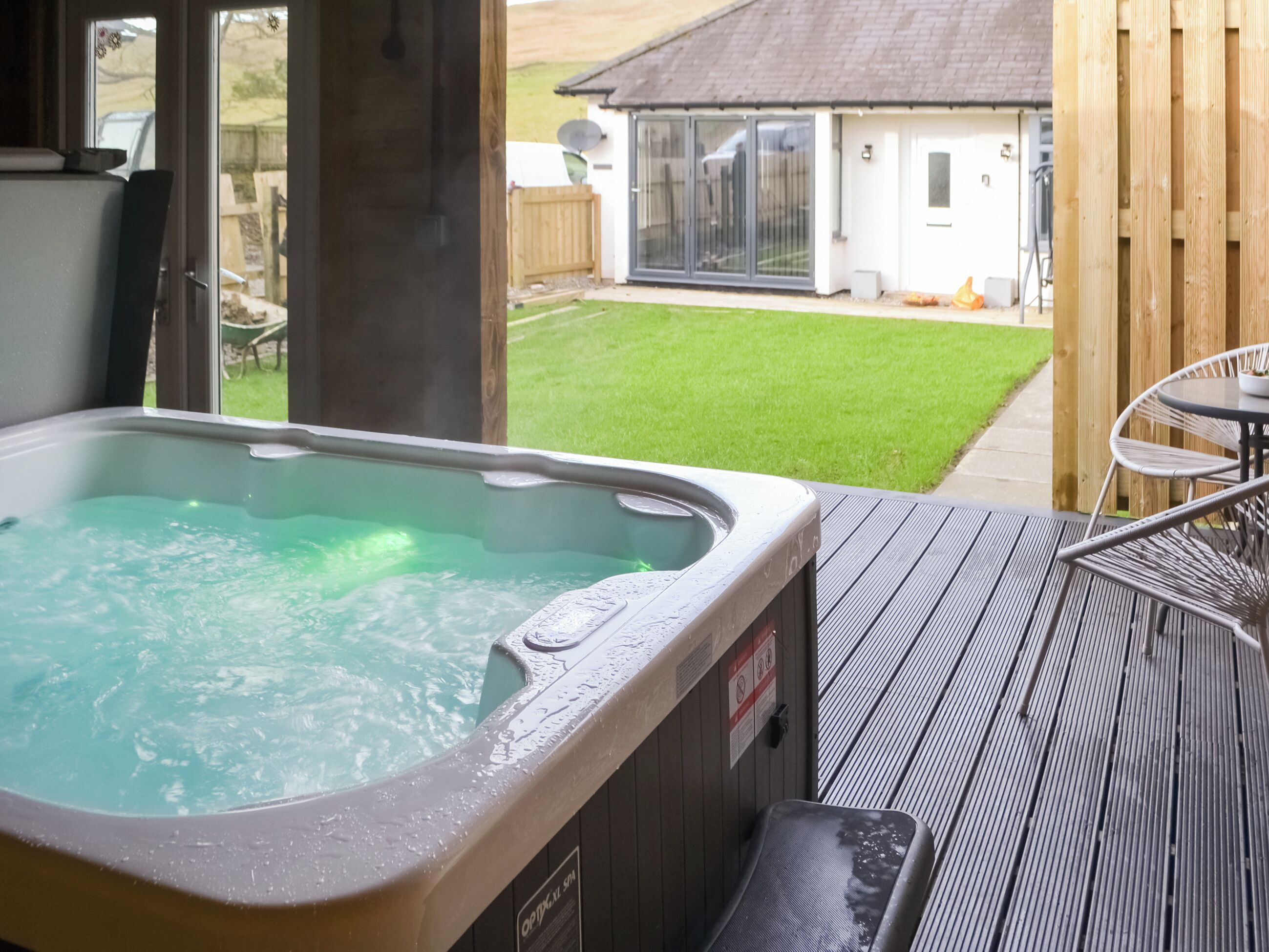 A hot tub with a view of a house and a lawn.