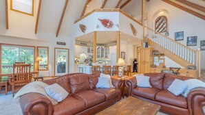 A spacious living room with leather sofas, a wooden coffee table, and a staircase leading to an upper level. - Bear House - Walking Distance to Snowflake Lodge, Pool,Lake and Recreation! (Arnold)