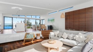 A spacious living area with a large window overlooking a scenic view, a modern kitchen, and a cozy seating area with a round coffee table.