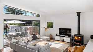 A modern living room with a sofa, TV, and fireplace.