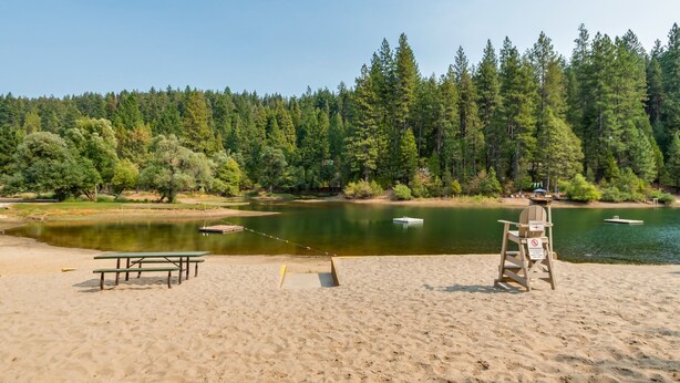 Une plage équipée de tables de pique-nique et d’un poste de surveillance pour les sauveteurs.