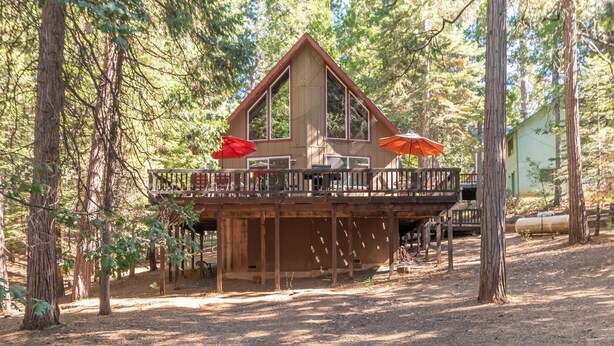 A cabin with a deck, surrounded by trees. - Pop's Place - Air Conditioned Cabin w/ Access to Golf and BLS (Arnold)