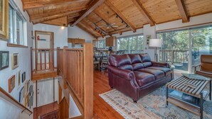 A spacious living area with a wooden ceiling, a leather sofa, and a dining table.