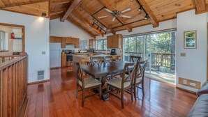 A spacious kitchen with wooden cabinets, a large island, and a dining area with wooden chairs.