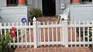 A house with a white exterior, a black front door, and a white picket fence. - Beach, bay, town, walking distance.  Large private fenced in home (Coronado)