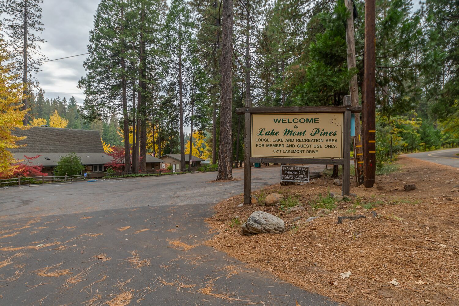 Un panneau d’accueil indique que le stationnement du Lake Mont Pines Lodge est réservé aux membres et à leurs invités.