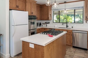 Enjoy cooking in this kitchen with a central island, gas stove, oven, and dishwasher.