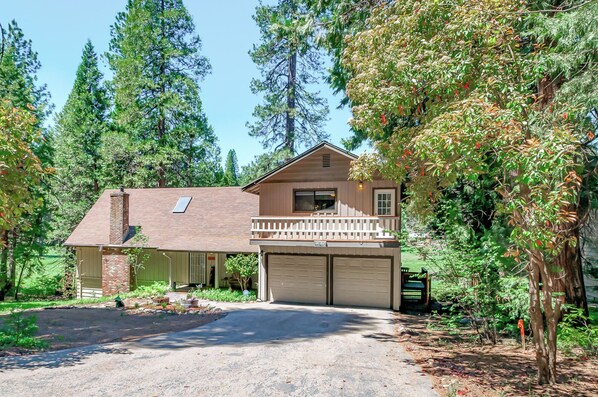 A two-story house with a front porch, garage, and a driveway.