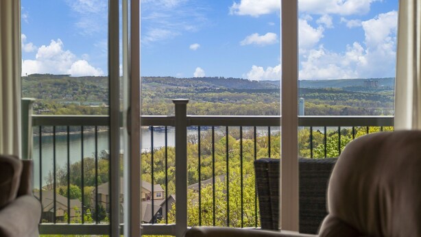 Un balcon avec vue sur un lac et des collines.
