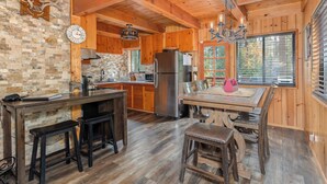 Una cucina rustica con mobili in legno, un frigorifero in acciaio inox, una parete di fondo in pietra e un'ampia finestra.