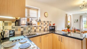 A modern kitchen with a gas stove, a microwave, and a sink.
